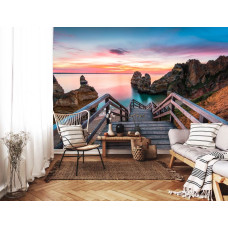 Een fotobehang van een brug naar het strand in een warme huiskamer.