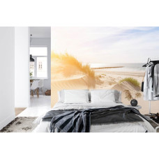 Een fotobehang van serene duinen en een strand met uitzicht op zee, perfect voor een slaapkamer.