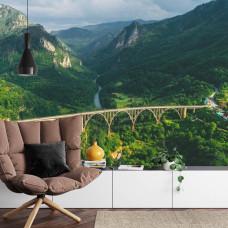 Een fotobehang met de Durdevica Tara-brug in een berglandschap, weergegeven in een woonkamer.