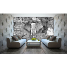Een fotobehang van een olifant uitgehouwen in rotsen in een abstract en kunstzinnig design, grijze tinten.