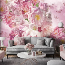 Een fotobehang van geschilderde pioenrozen en vlinders in roze tinten in een huiskamer.