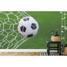 Een fotobehang met een voetbal in een actievolle doelpoging in een kinderkamer.