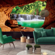 Een fotobehang van een grot met uitzicht op een waterval in de jungle voor de huiskamer.