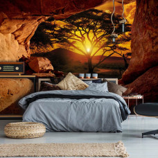 Een fotobehang van een grot met uitzicht op een zonsondergang voor de slaapkamer.