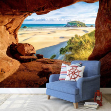 Een fotobehang van een grot met uitzicht op het strand en duinen in de woonkamer.
