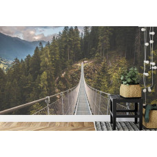 Een fotobehang met een berglandschap en een hangbrug, afgebeeld in een huiskamer.