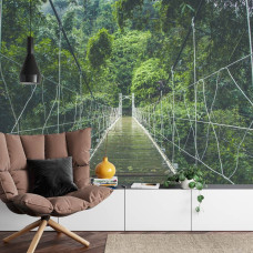 Een fotobehang met een hangbrug in een dicht regenwoud, afgebeeld in een woonkamer.