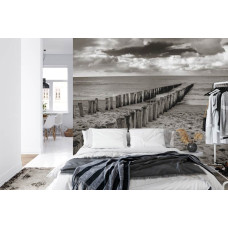 Een fotobehang met een rustgevend strandbeeld in zwart-wit, geschikt voor een slaapkamer.