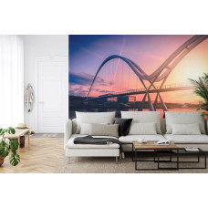 Een fotobehang met een iconische brug en zonsondergang, weergegeven in een huiskamer.
