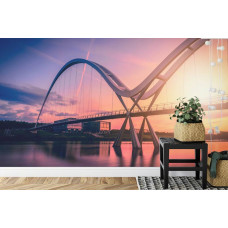 Een fotobehang met de Infinity Bridge in Engeland tijdens zonsondergang, weergegeven in een slaapkamer.