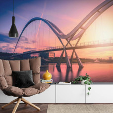 Een fotobehang met de Infinity Bridge tegen een kleurrijke zonsondergang, afgebeeld in een woonkamer.