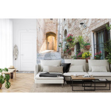 Een fotobehang met een Italiaanse steeg en oude architectuur, afgebeeld in een woonkamer.