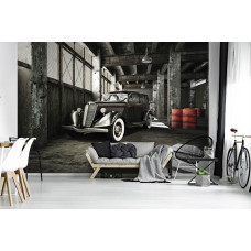 Een fotobehang van een klassieke auto in een oude garage voor de woonkamer.