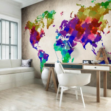 Een fotobehang van een wereldkaart met kleurrijke steden en abstracte vormen in een woonkamer.