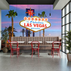 Fotobehang Las Vegas met iconisch welkomstbord, kleurrijke neonverlichting en palmbomen als sfeervolle wanddecoratie in een restaurant.