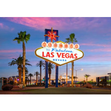 Fotobehang Las Vegas met beroemd welkomstbord, neonverlichting en palmbomen bij zonsondergang.