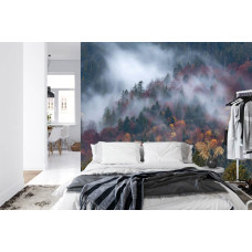 Een fotobehang met een nevelige bergoase en bergen gehuld in ochtendmist afgebeeld in een slaapkamer.