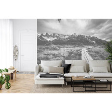 Een fotobehang met een sfeervolle weg door een berglandschap, perfect voor een huiskamer.
