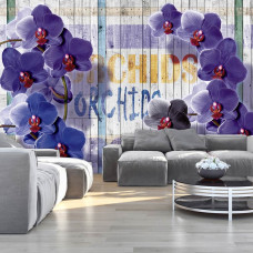 Een fotobehang met een bloemenpatroon van orchideeėn in de huiskamer.