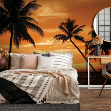 Een fotobehang met palmbomen in silhouet tegen een kleurrijke zonsondergang.