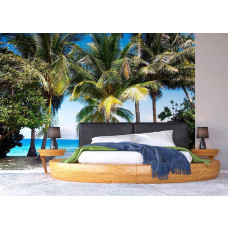 Een fotobehang van palmbomen langs de zee in een slaapkamer.