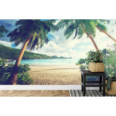 Een fotobehang met palmbomen op een tropisch strand bij een rustige zee, afgebeeld in een slaapkamer.