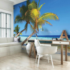 Een fotobehang met palmbomen aan een zonnig strand met zee, zichtbaar in een kantoor.
