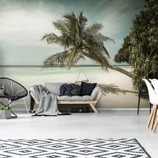 Fotobehang van een schommel aan het strand met palmbomen en de zee op de achtergrond, geschikt voor de woonkamer.