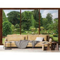 Een fotobehang met een raamzicht op een botanische tuin, waarin tropische planten en bloemen het uitzicht domineren, dat een frisse uitstraling geeft aan een woonkamer.