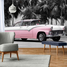 Fotobehang van een roze retro-auto onder palmbomen in Cuba, levendig en passend in de woonkamer.