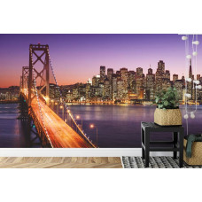 Een fotobehang met een sfeervolle nachtelijke scčne van de Bay Bridge, afgebeeld in een slaapkamer.
