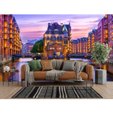 Fotobehang Speicherstadt Hamburg bij Avondlicht in de woonkamer met historische pakhuizen en warm avondlicht.