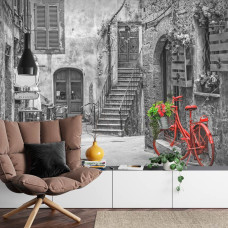 Een fotobehang met een kleurrijke Toscaanse straat, afgebeeld in een slaapkamer.