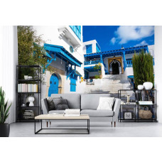 Een fotobehang met een schilderachtige straat in Tunesiė, omgeven door blauwe huizen, perfect voor een woonkamer.