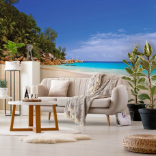 Een fotobehang van een strand en zee, passend voor een huiskamer.