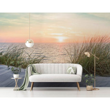 Een fotobehang van een strand en duinen bij zonsondergang aan zee voor de huiskamer.