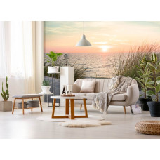 Een fotobehang van een strand en duinen bij zonsondergang aan zee voor de woonkamer.