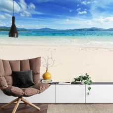 Een prachtig fotobehang van een strand en zee in blauwe tinten, ideaal voor een huiskamer.