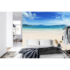 Een sfeervol fotobehang met een strand en zee, geschikt voor een slaapkamer.