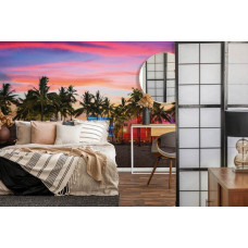 Fotobehang van een rustig strand bij zonsondergang, met palmbomen en een zachte avondgloed, passend in de slaapkamer.