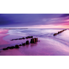 Fotobehang met een gekleurde horizon bij een zonsondergang aan zee.