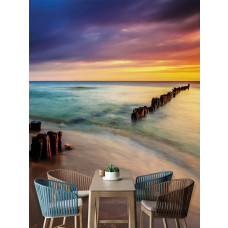 Een fotobehang met een strand bij zonsondergang en kleurrijke horizon, geplaatst in een keukenomgeving.