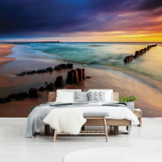 Een fotobehang met een strandlandschap bij zonsondergang en een kleurrijke horizon.
