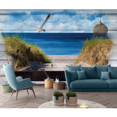Een fotobehang van een kustlandschap met zee en duinen op een houten plank achtergrond in een woonkamer.