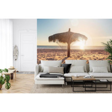 Een fotobehang met een kleurrijke zonsondergang op een tropisch strand, ideaal voor een woonkamer.