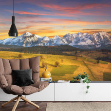 Een fotobehang met een zonsondergang boven het Tatra-gebergte in een huiskamer.