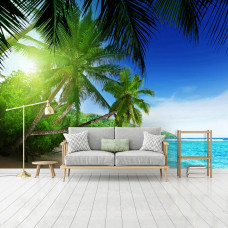 Een fotobehang met een tropisch strand met zon, zee en palmbomen, zichtbaar in een woonkamer.