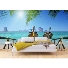 Een tropisch fotobehang met een zeezicht, kleurrijke bootjes en groene palmbladeren, perfect voor een kalme en exotische sfeer in een slaapkamer.