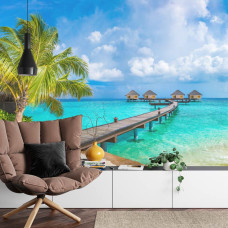 Een fotobehang met een tropisch strand en palmbomen in een woonkamer.