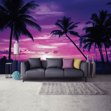 Een fotobehang met een tropische zonsondergang aan zee met palmbomen, zichtbaar in een huiskamer.